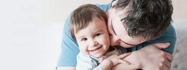 Parent hugging smiling baby