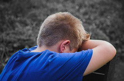 Teenager with head in hands